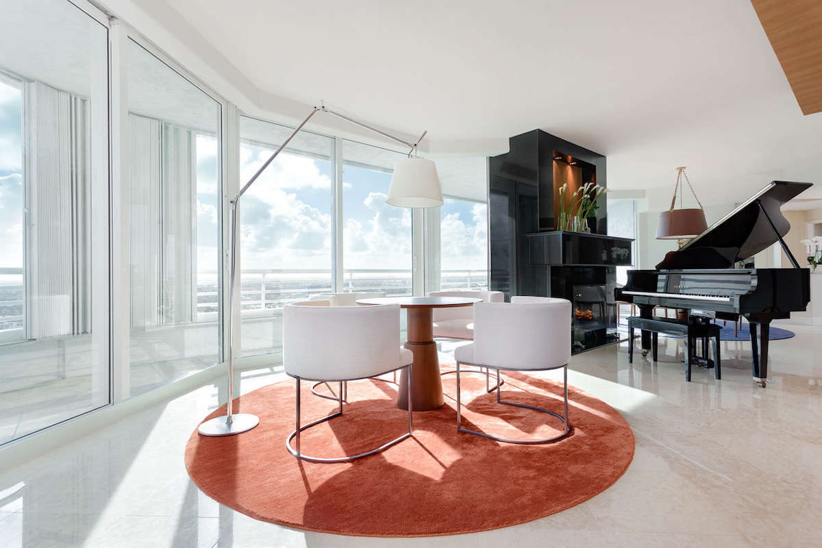 Round orange rug, circular dining table, white dining stools