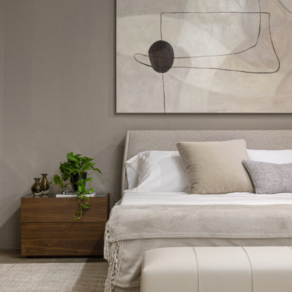 Brown night table, white bed, large wall art