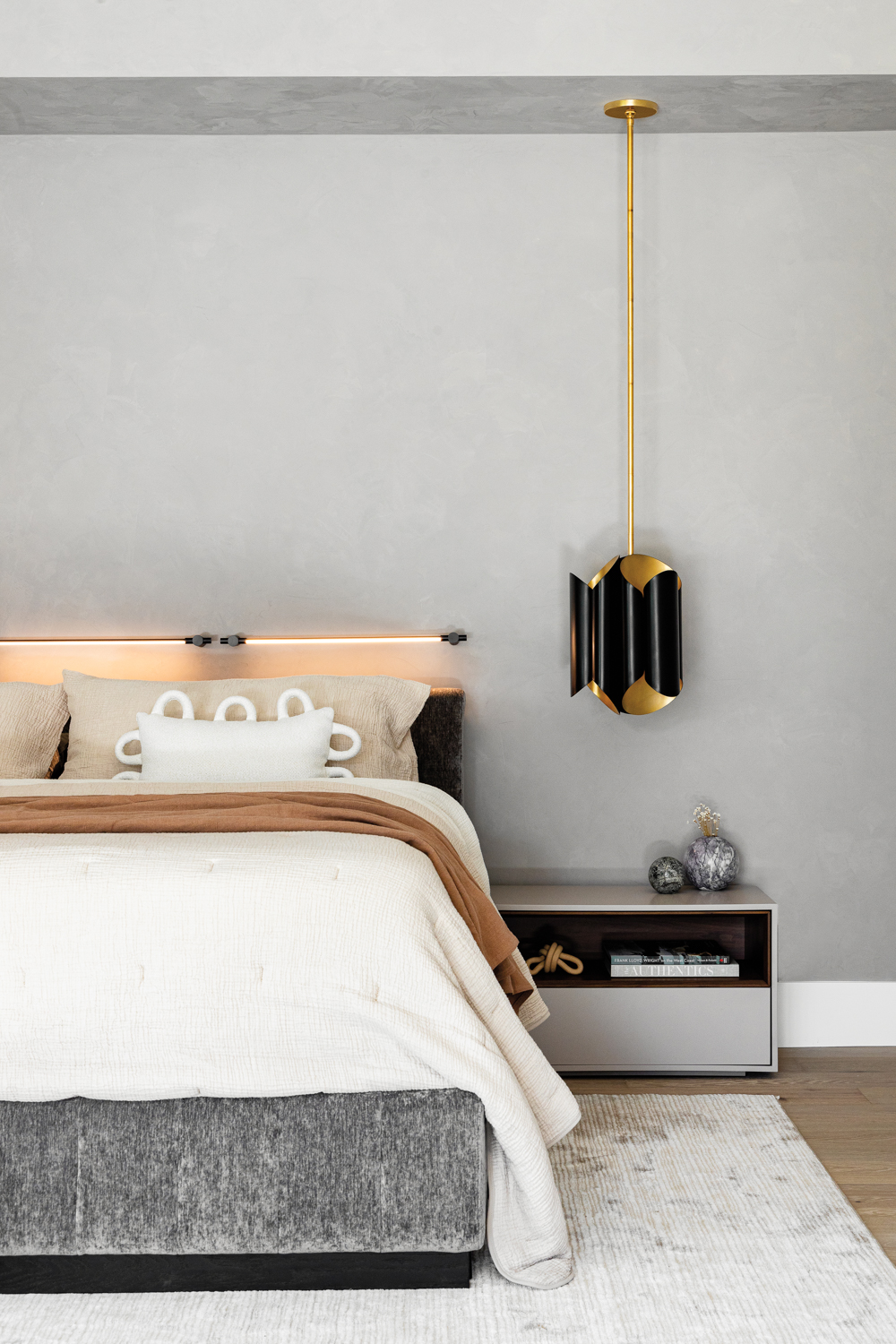 gray bedroom with black-and-brass pendant...