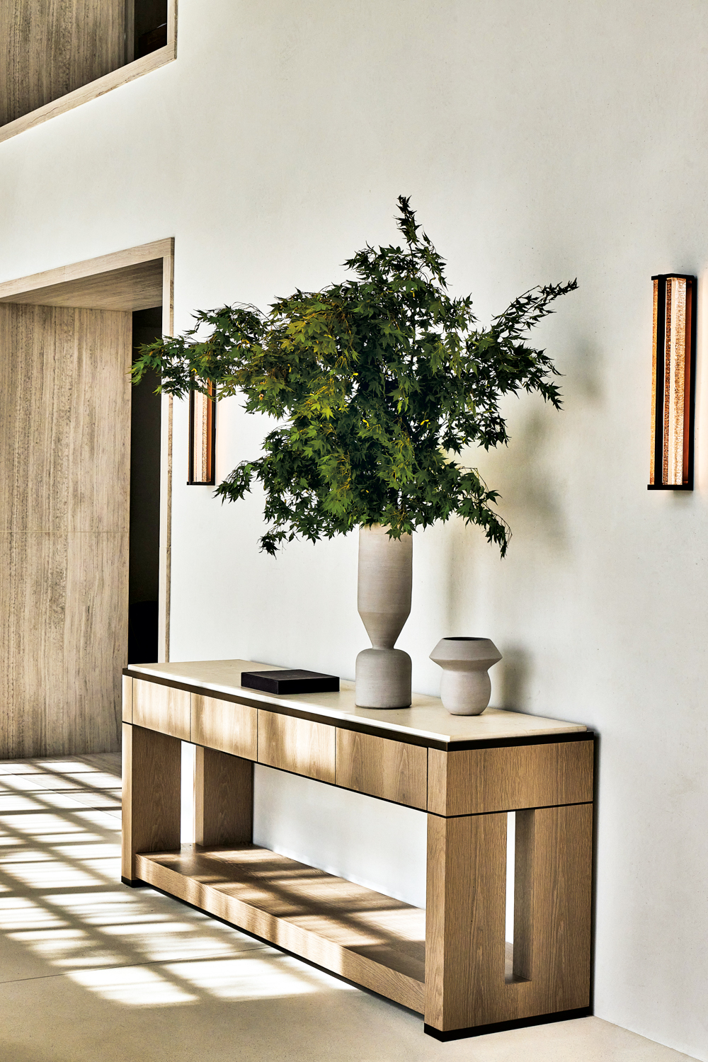 plant in white ceramic base on wooden console against white wall