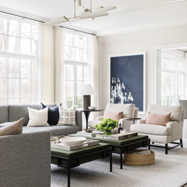 living room with gray sectional, two cream armchairs and blue-and-white abstract painting