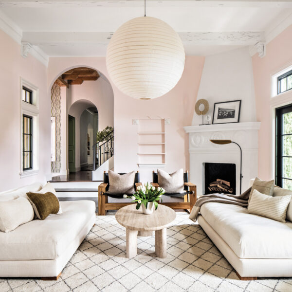 A 1920s Residence Gets A Twist On Traditional Palm Beach Style light pink living space with while couches and round lighting fixture