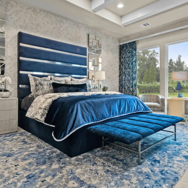Bedroom with blue velvet bed frame.