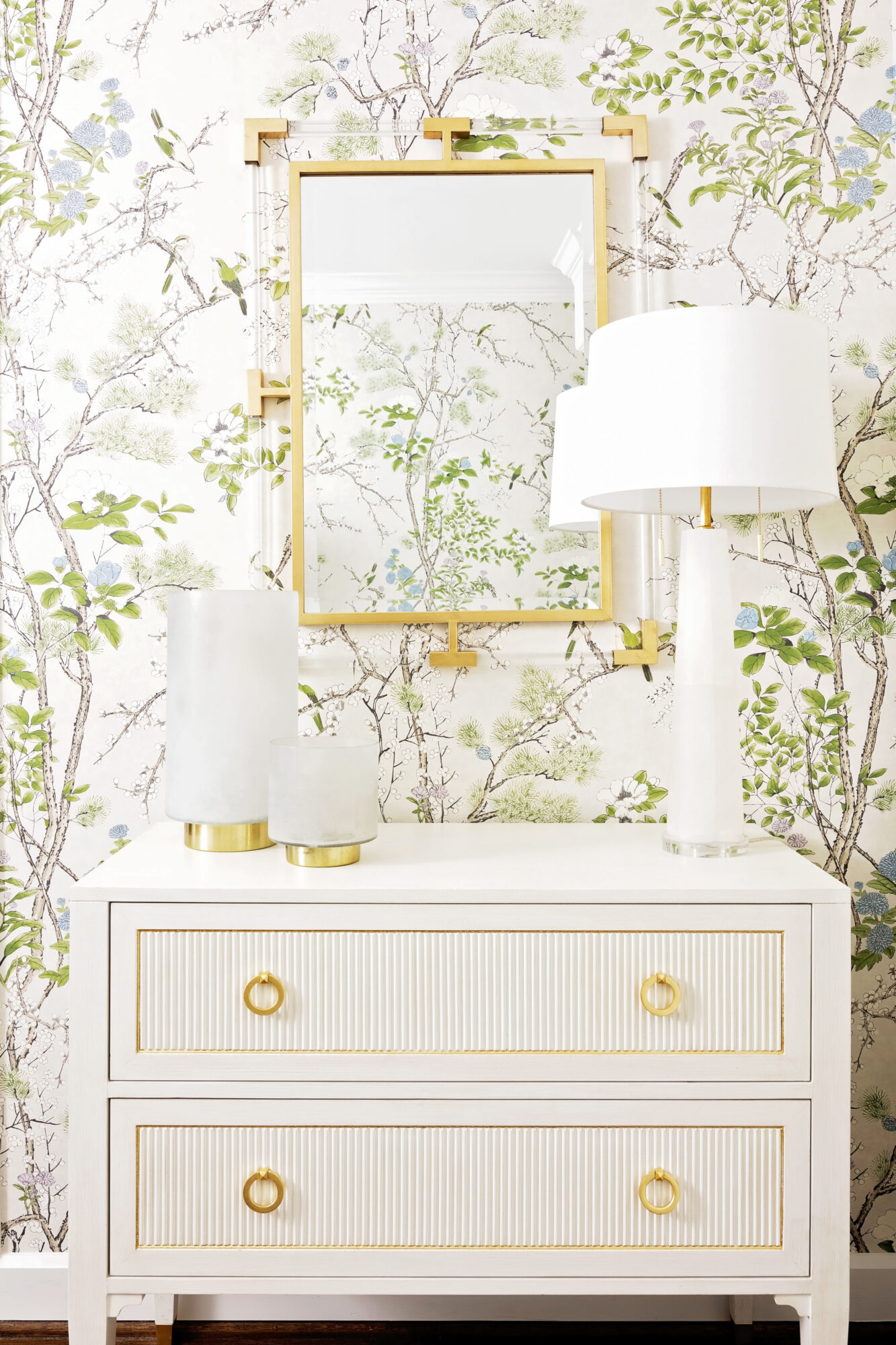 Elegant white dresser with gold accents and mirror, complemented by a botanical motif in a transitional palette of creamy whites and metallic gold.