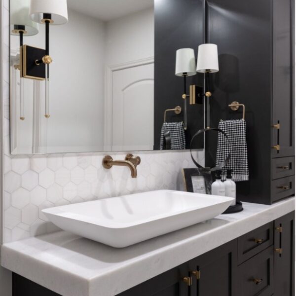 A tuxedo black and white master bath with sleek black cabinets and white countertops.