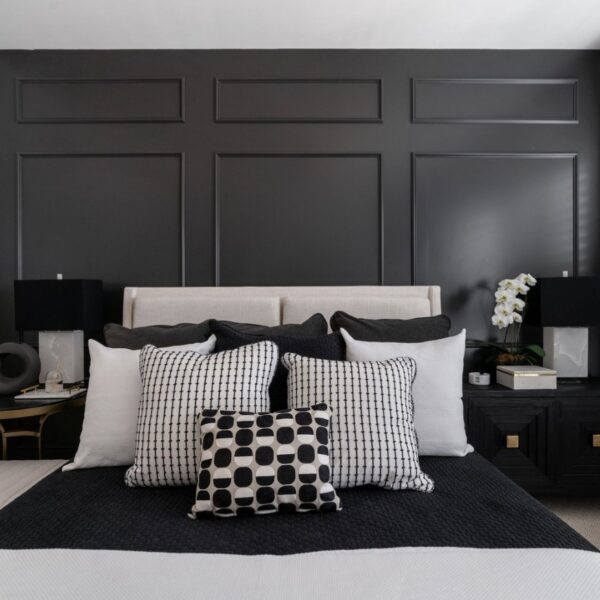 Monochrome bedroom with a stylish bed, featuring black and white decor.
