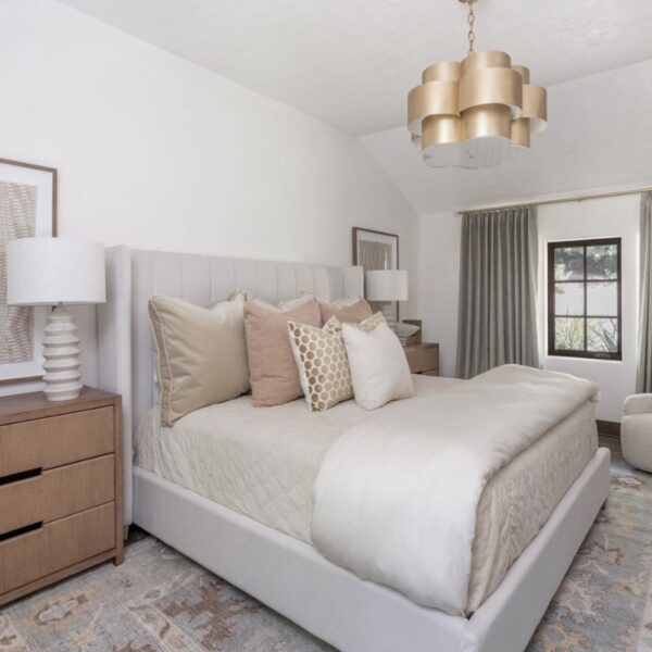A well-appointed bedroom showcasing a bed, dresser, and lamp in a harmonious arrangement.