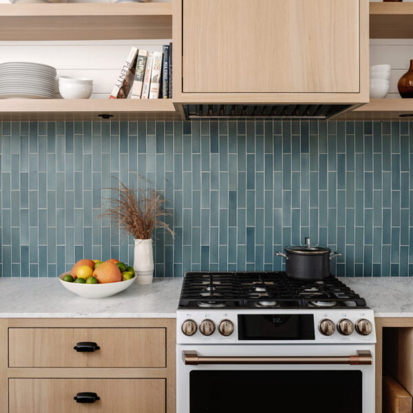 Blue vertical tile backsplash in kitchen with gas stove.