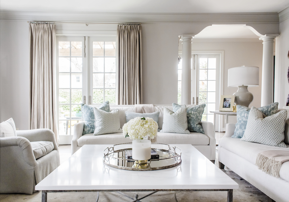 Custom pillows add a pop of color and movement, bringing this calm palette to life.