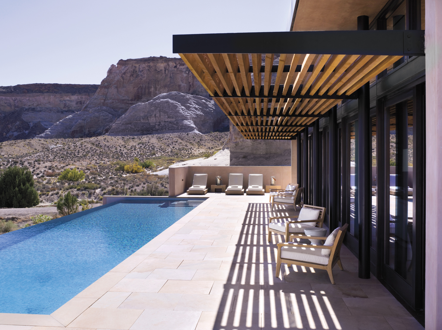 Hotel pool overlooking a mountainous desert landscape.