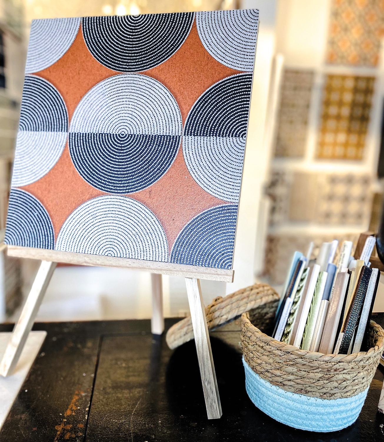 Orange tile with black-and-white circle print on an easel.
