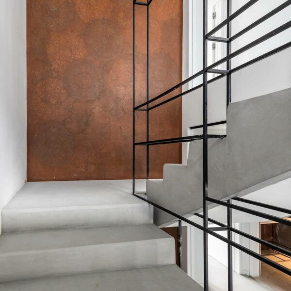 White staircase, iron railings, orange art