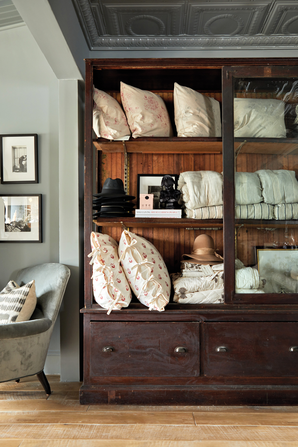 pillows and linens stored in a armoire with a sliding glass door at the Huntress boutique