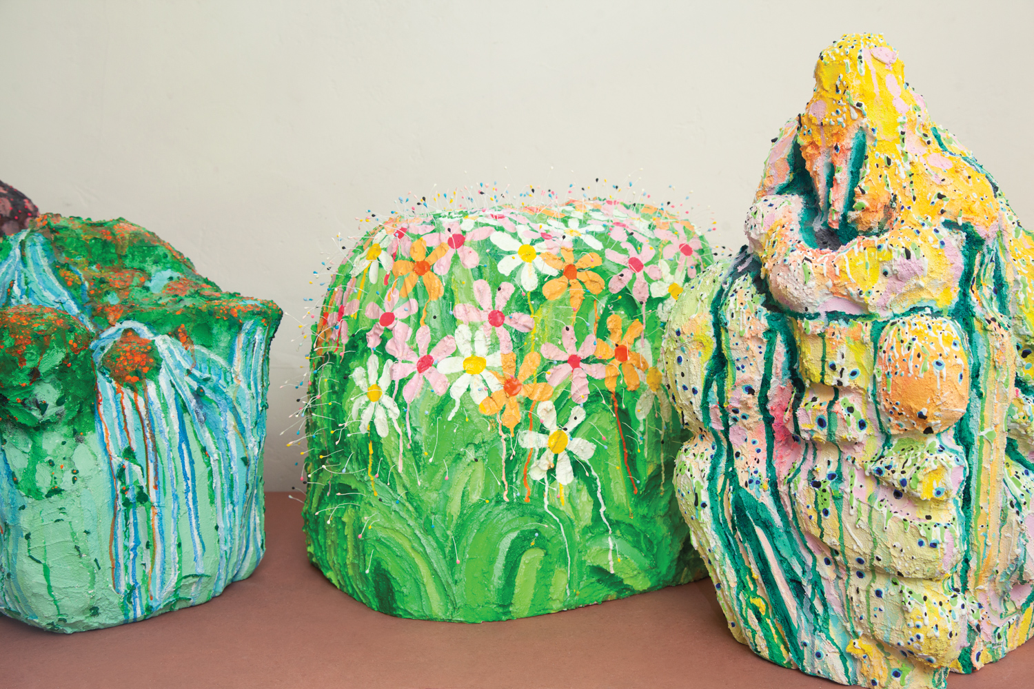 three brightly coloored styrofoam sculptures painted in greens, blues, yellows, oranges and pinks