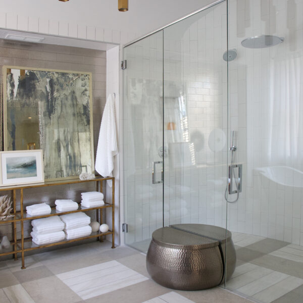 Glass shower door with gold lighting and modern wall art by Construction Resources in Georgia