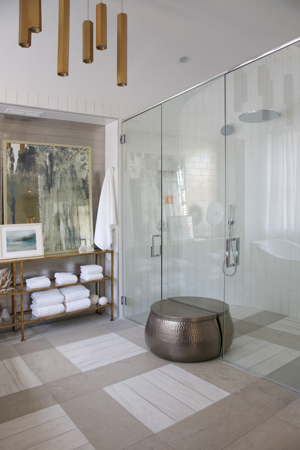 Glass shower door with gold lighting and modern wall art by Construction Resources in Georgia