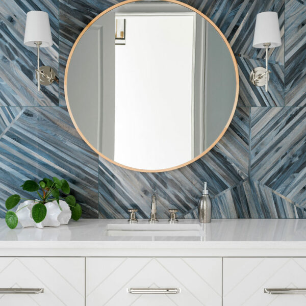 bathroom with white floating cabinets and blue tile backsplash, gold and silver fixtures by Construction Resources in Georgia