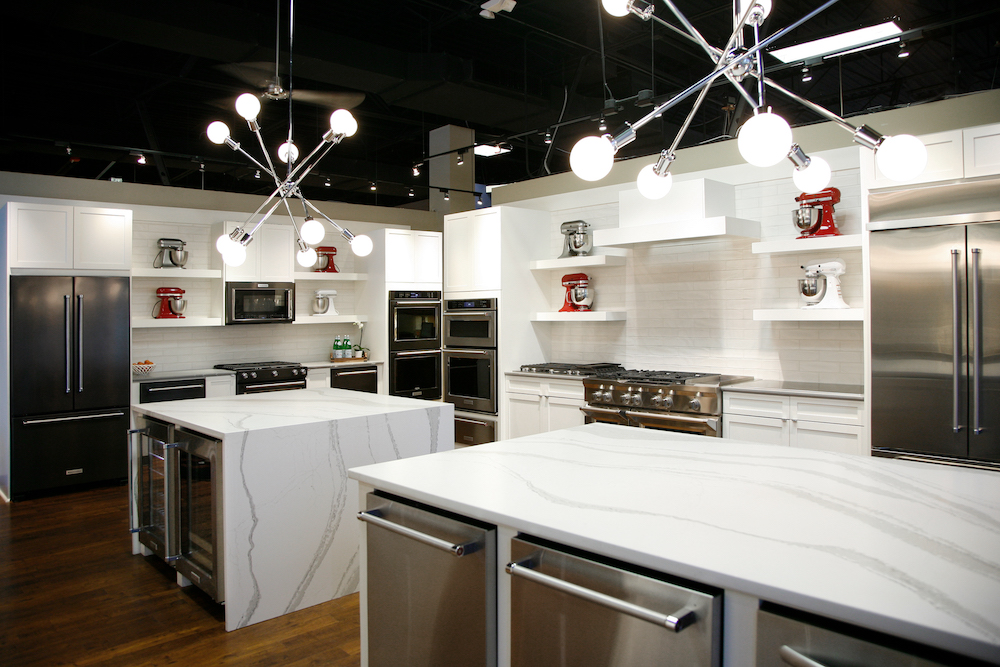 white countertops and stainless steel appliances with modern lighting chandeliers in Georgia by Construction Resources