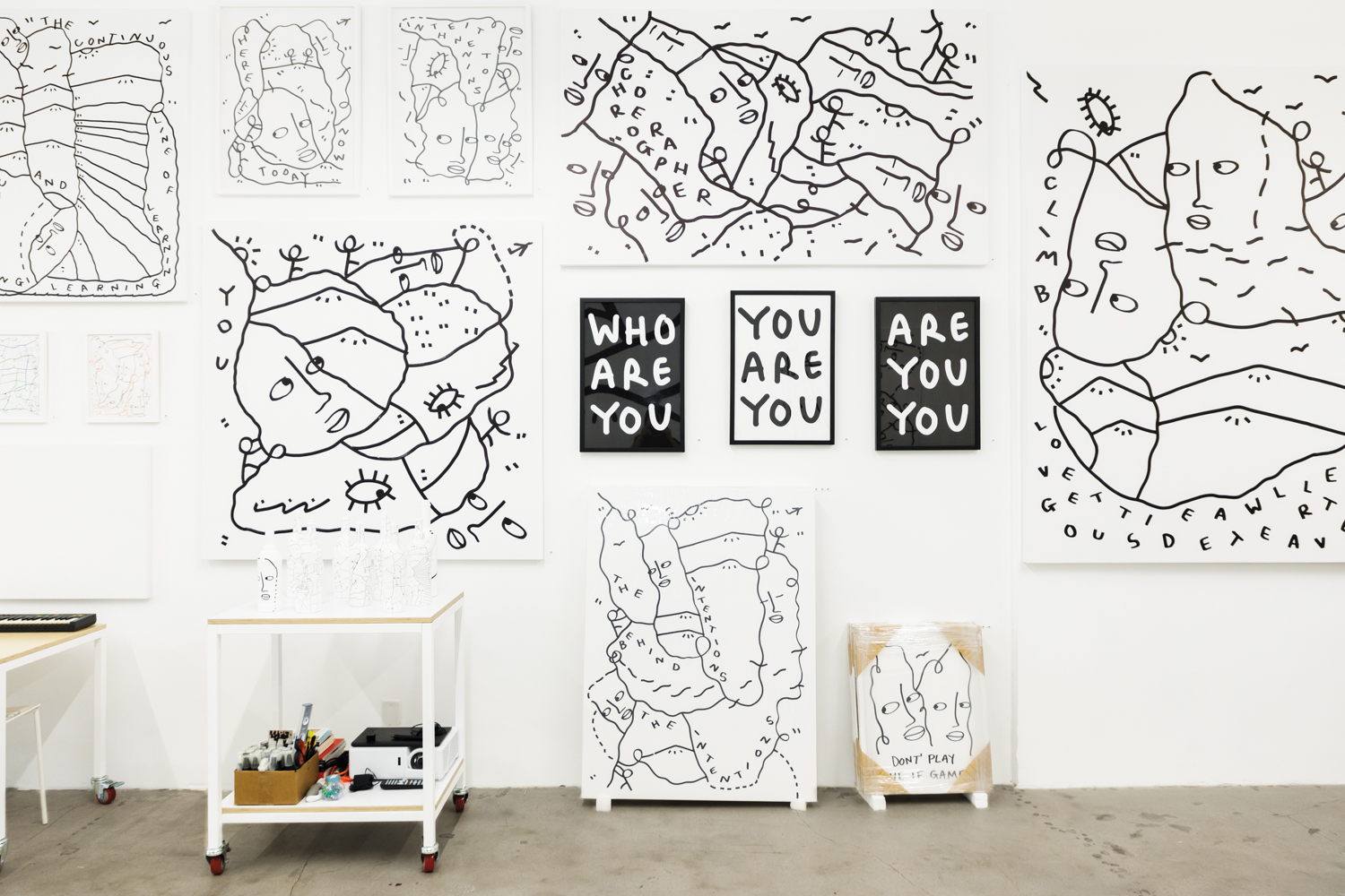 Artworks by Shantell Martin in her studio space, some hanging on the wall and other on the floor