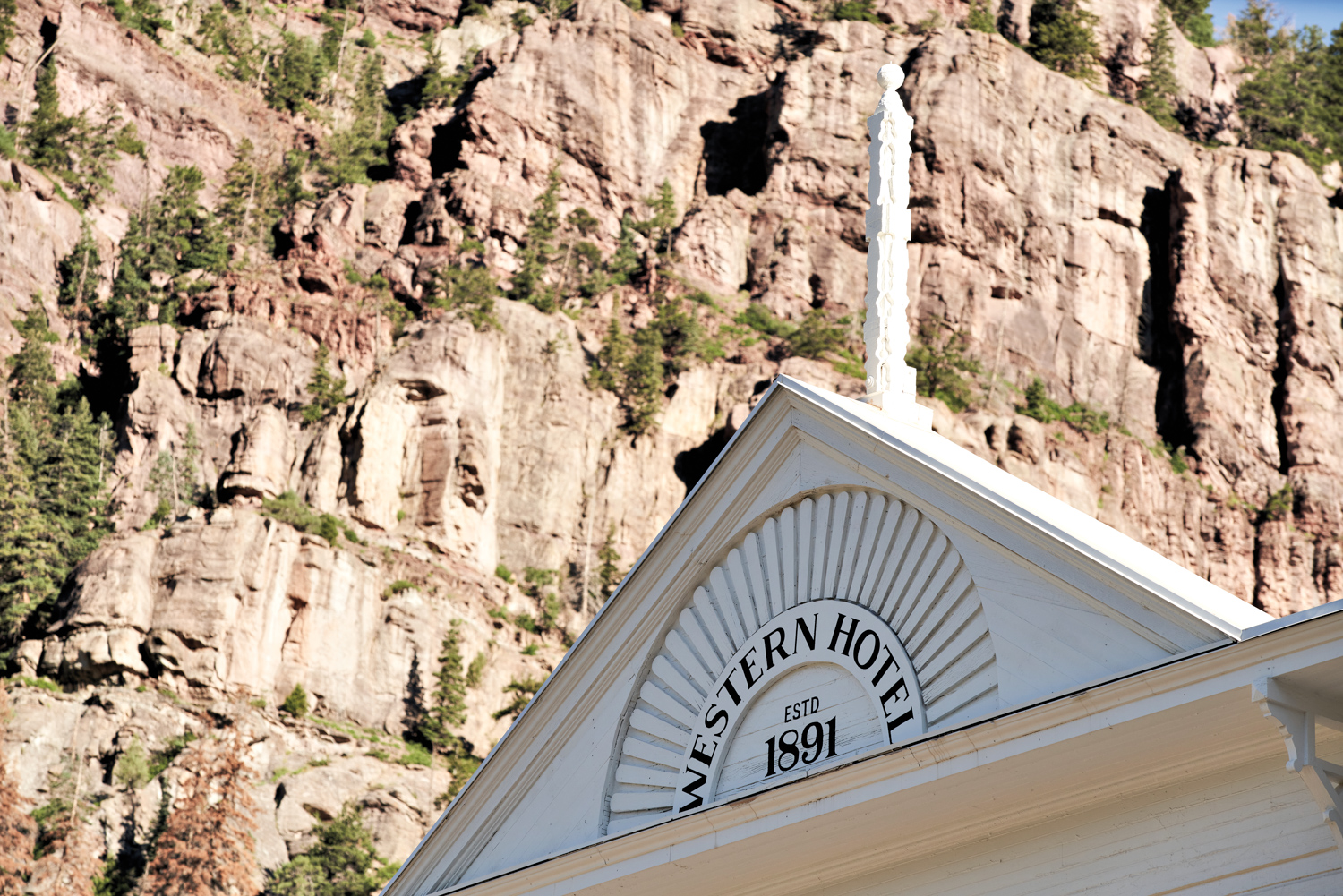 Detail shot of the exterior facade of the Western hotel's historic building with the side of a mountain as backdrop