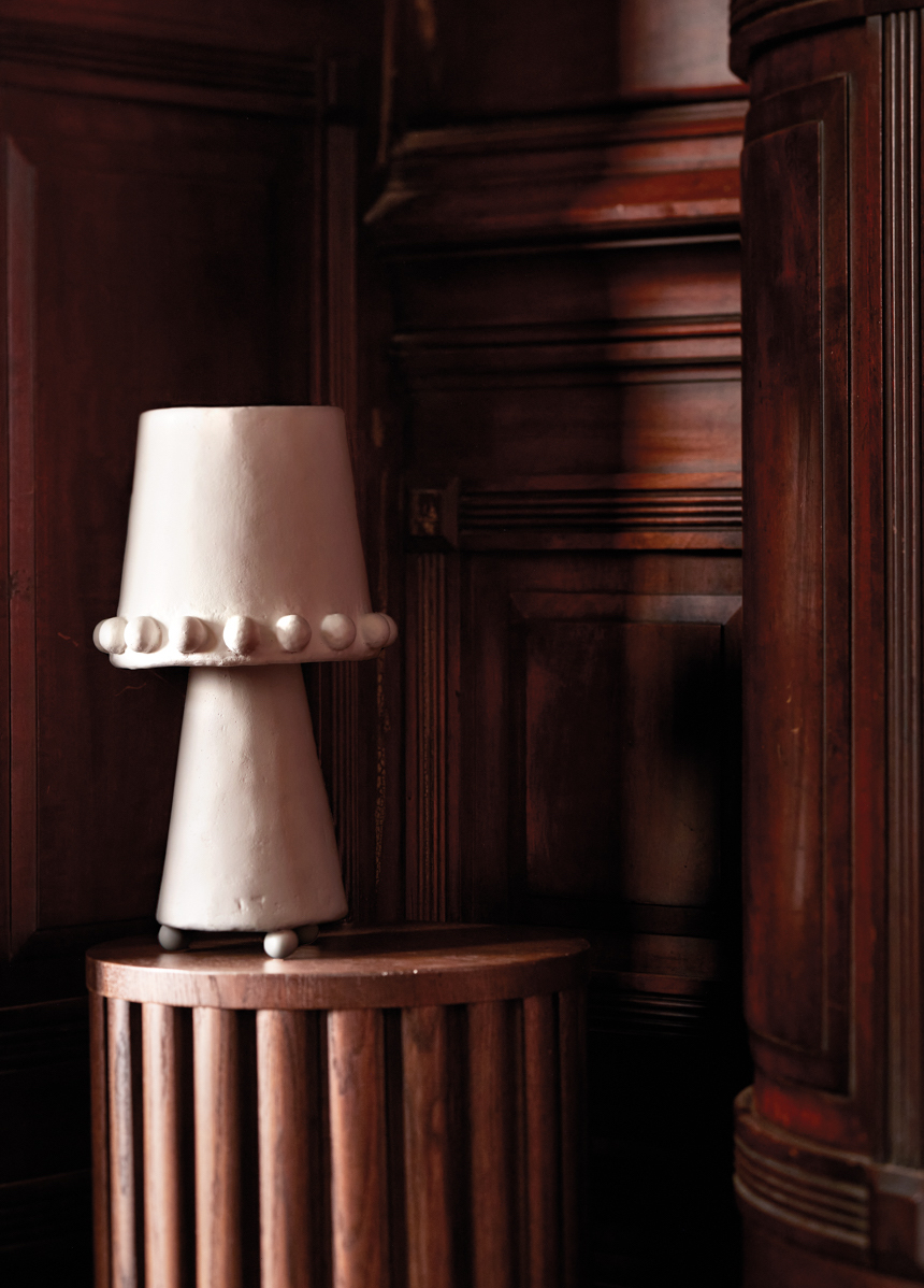 Brent Warr’s Katie contemporary table lamp is shown atop the wood Paleta pedestal from Arhaus