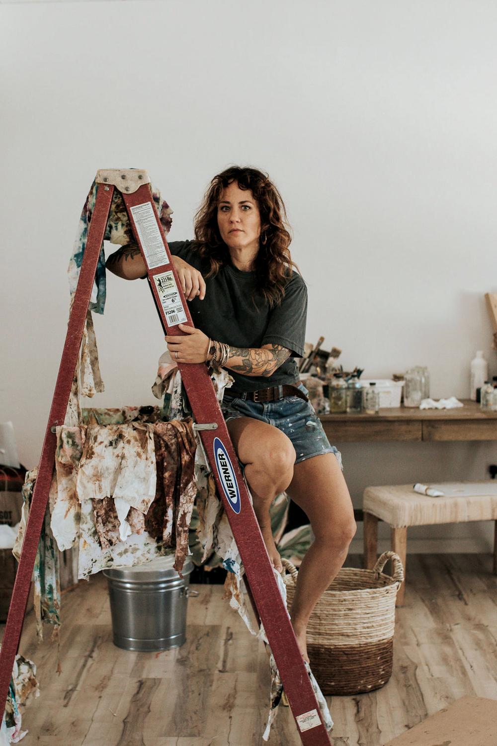 Kristy Gammill sitting on a red ladder draped with worn rags