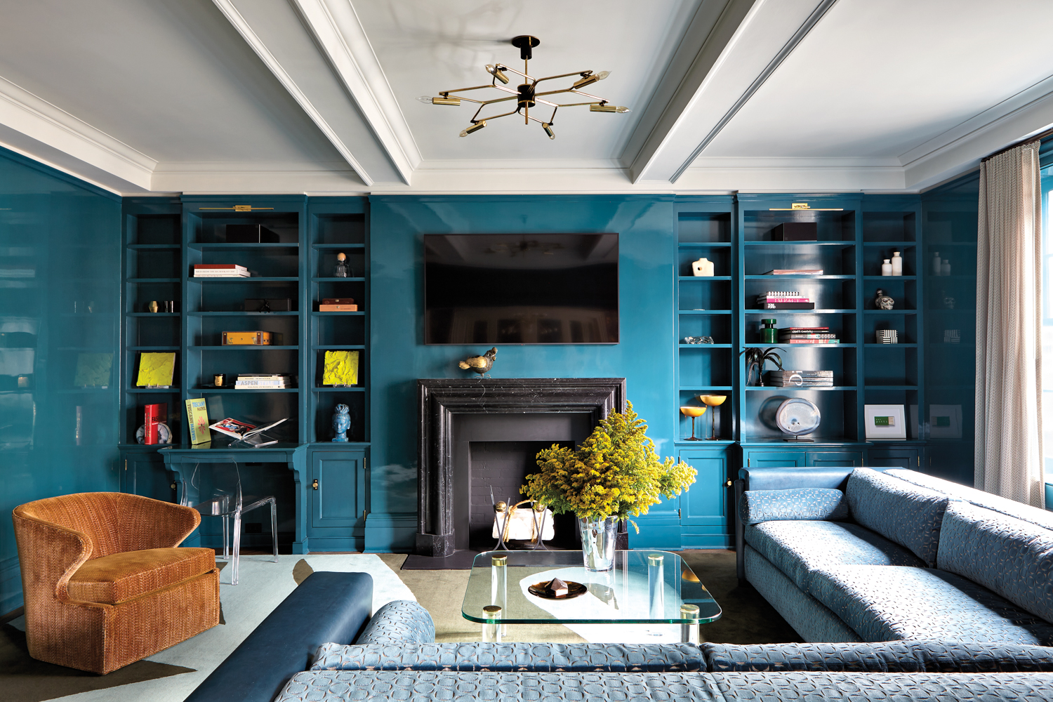 teal lacquer den with bookshelves and seating