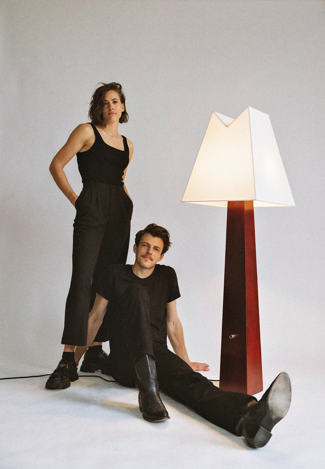Portrait of Chelsie and Jacob Starley next to the Alpine floor lamp from Astraeus Clarke.