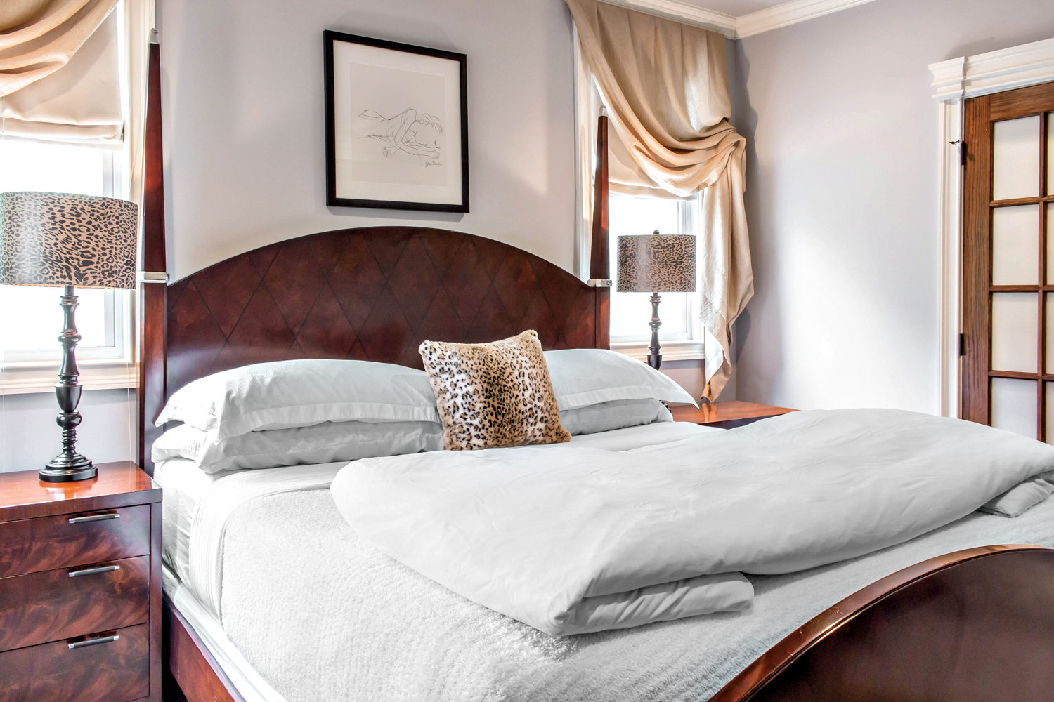 King sized bed with white bedding and wooden headboard