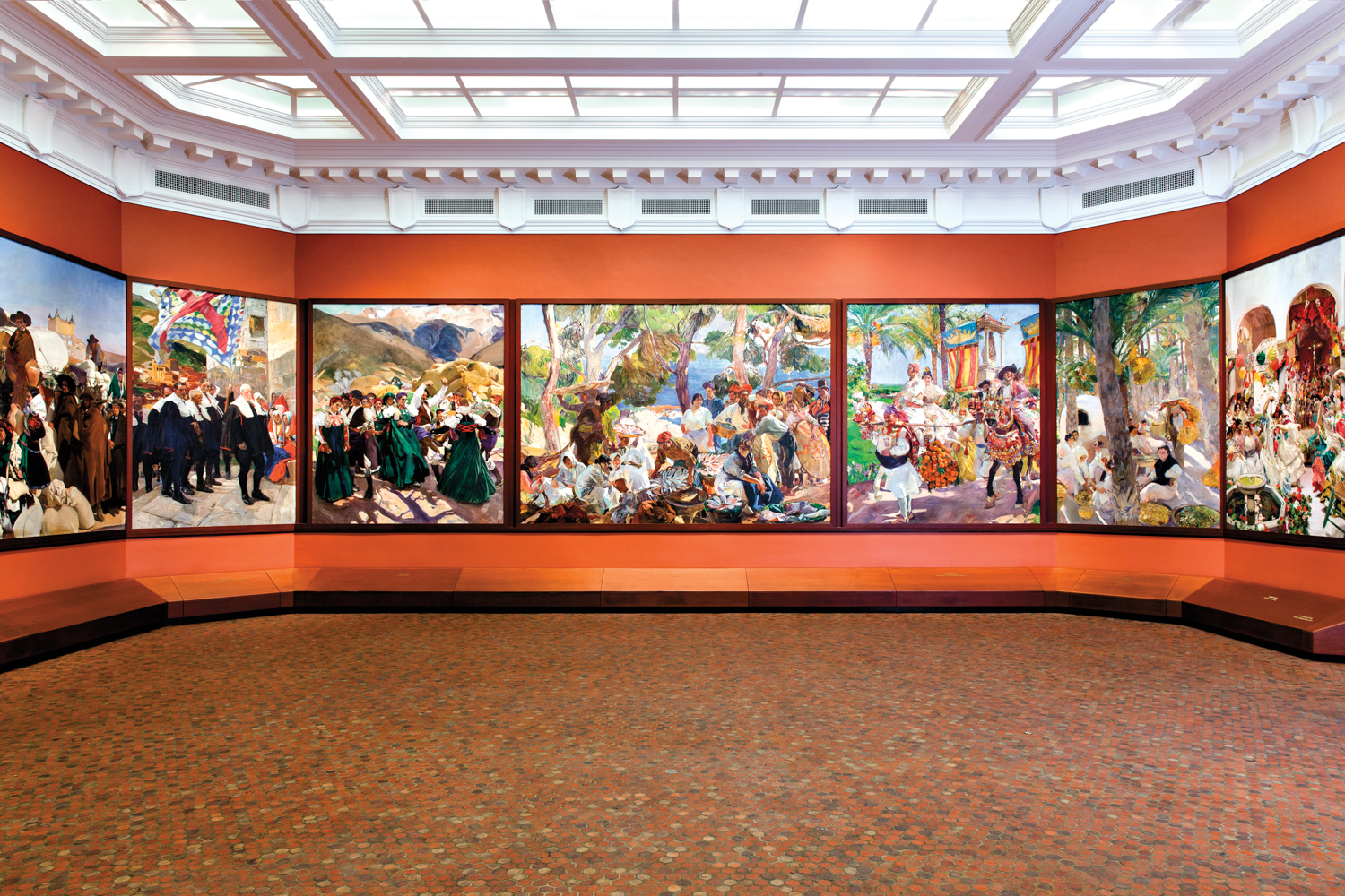 Gallery wall covered with a row of large paintings under a windowed ceiling