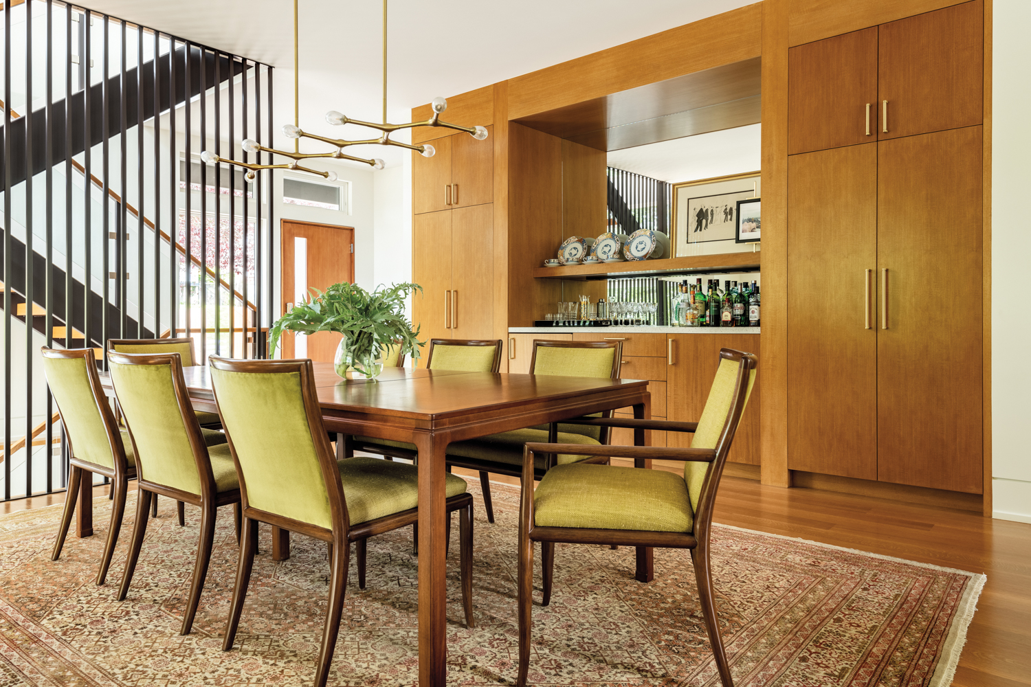 Green-upholstered chairs surround the dining...