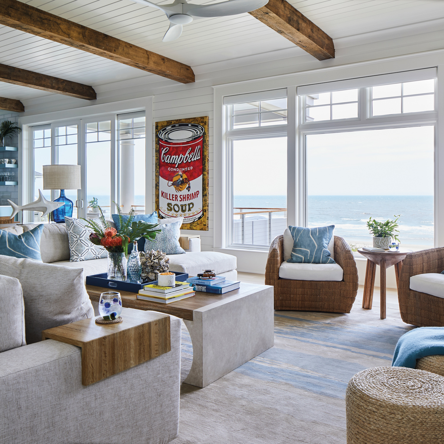 Living room with ocean views, neutral upholstery and brown wood ceiling beams