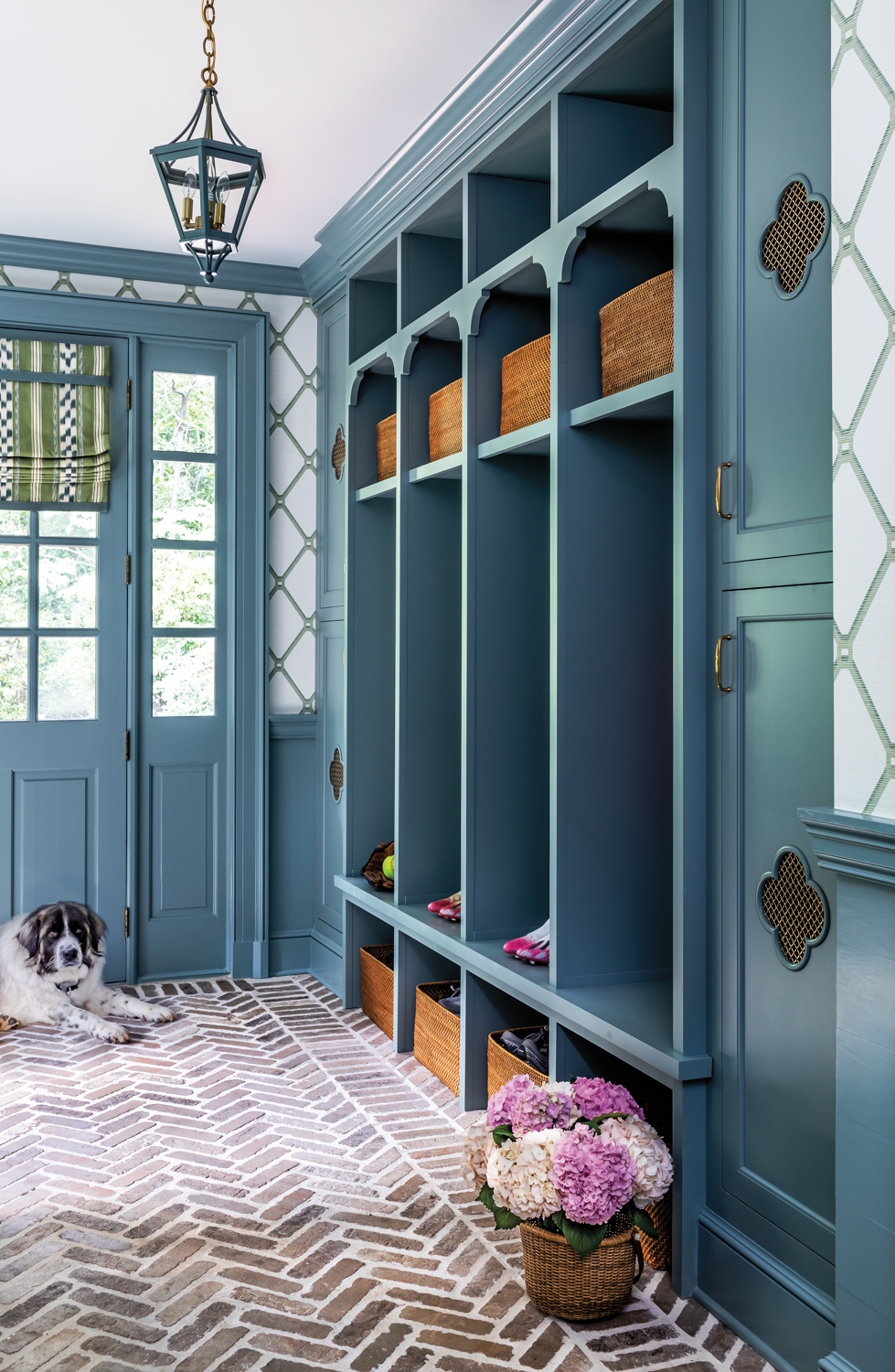 Mudroom with blue cabinetry, diamond-patterned...