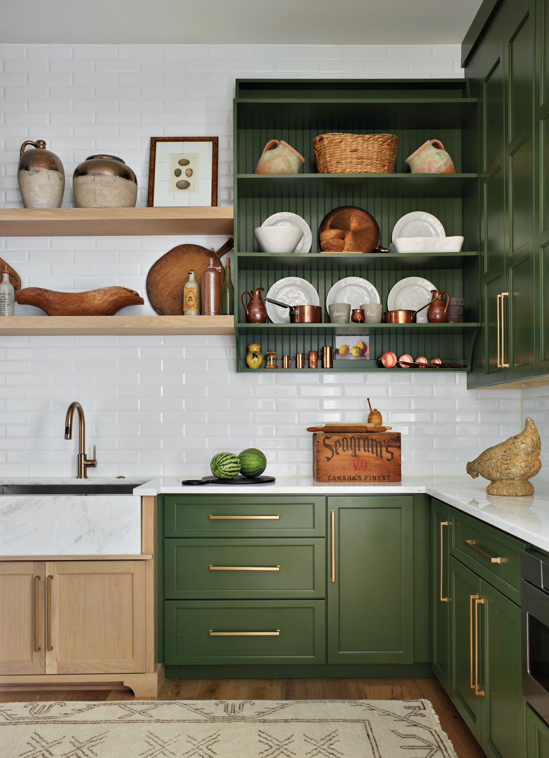 Kitchen with green cabinetry, brass...