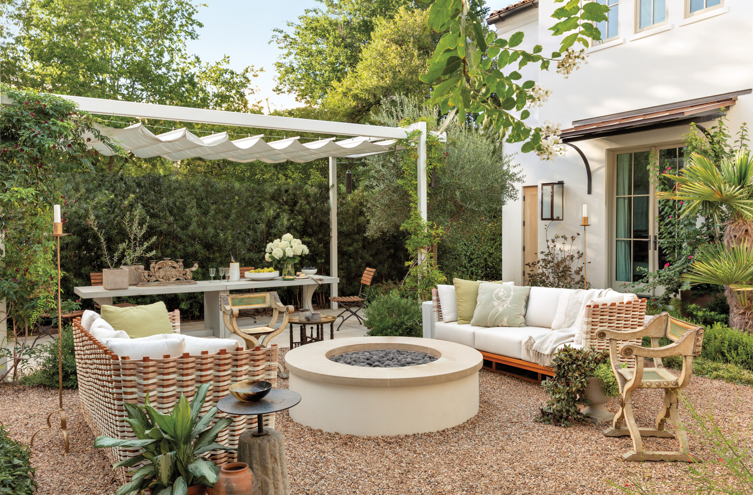 lush courtyard with a fire pit seating area and covered dining area for entertaining