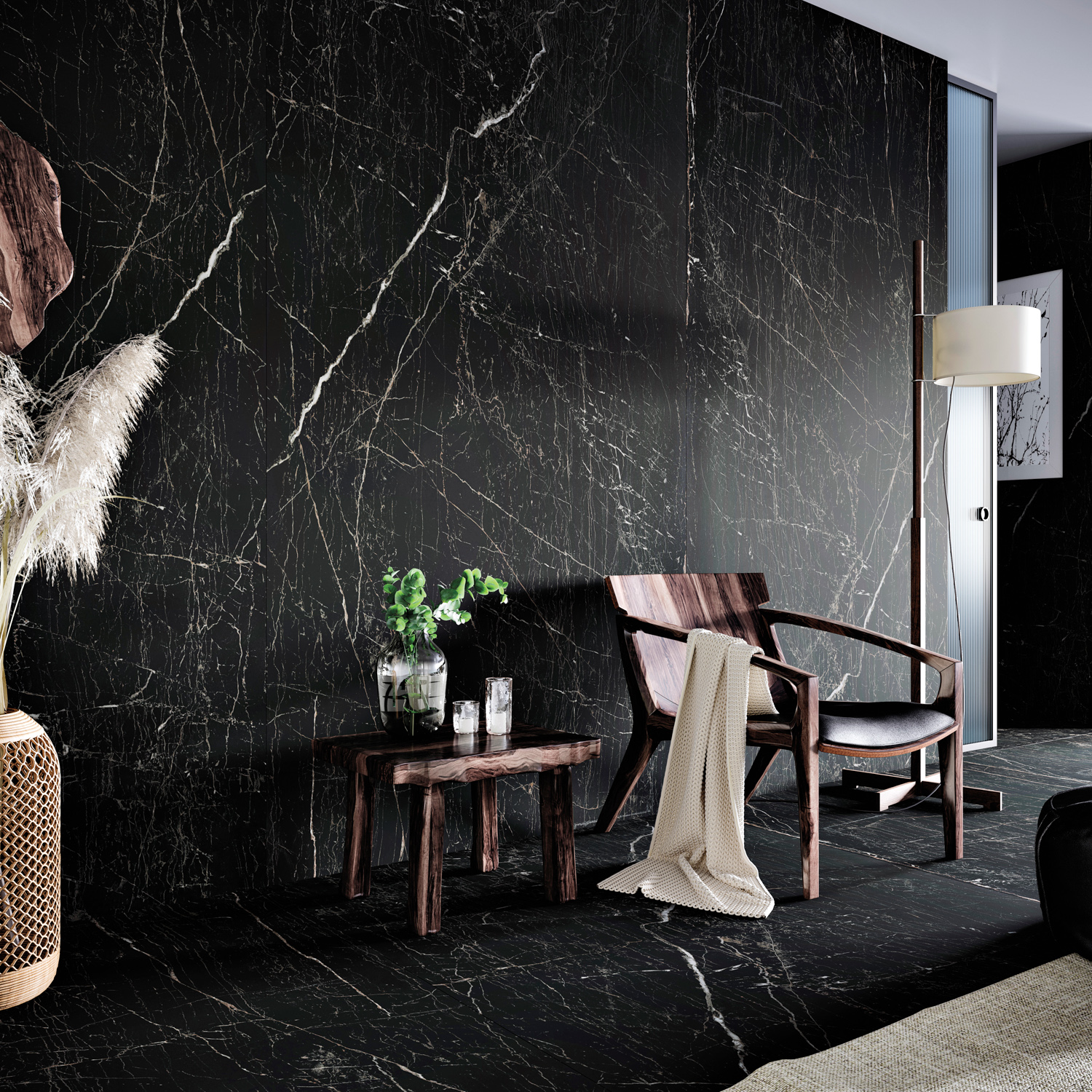 white-veined black marble-inspired material runs floor to ceiling grounding a seating area with a dark walnut chair and side table