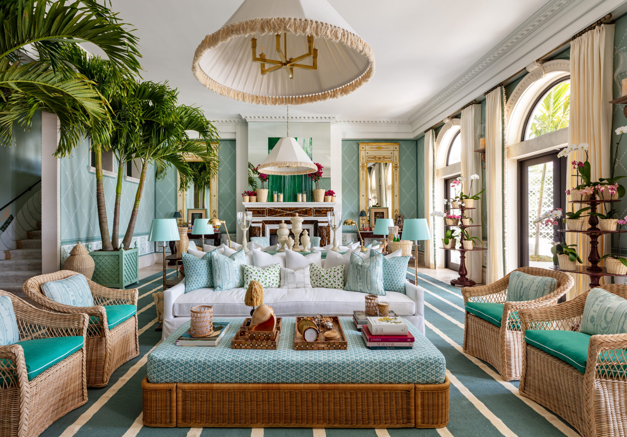 maximalist grand living room with antique furnishings, rattan furniture and palm trees