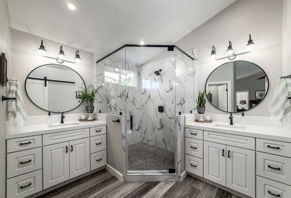 marble shower with white cabinets in Southern California home by Coastal Home Design Studio