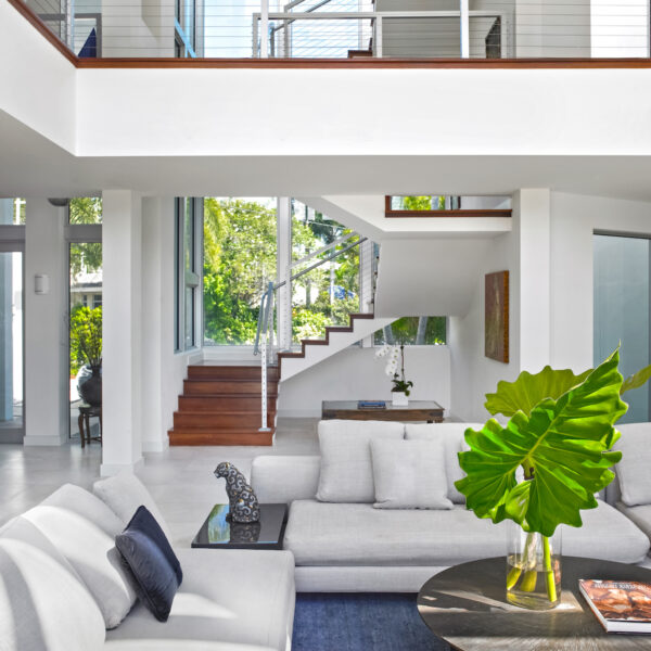 two story view, blue area rug, wooden stairs, white couches