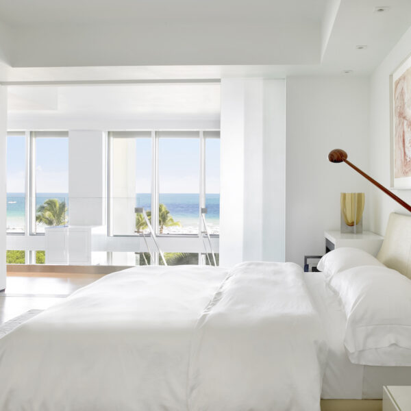 white bedroom, wall art, open windows, large shades