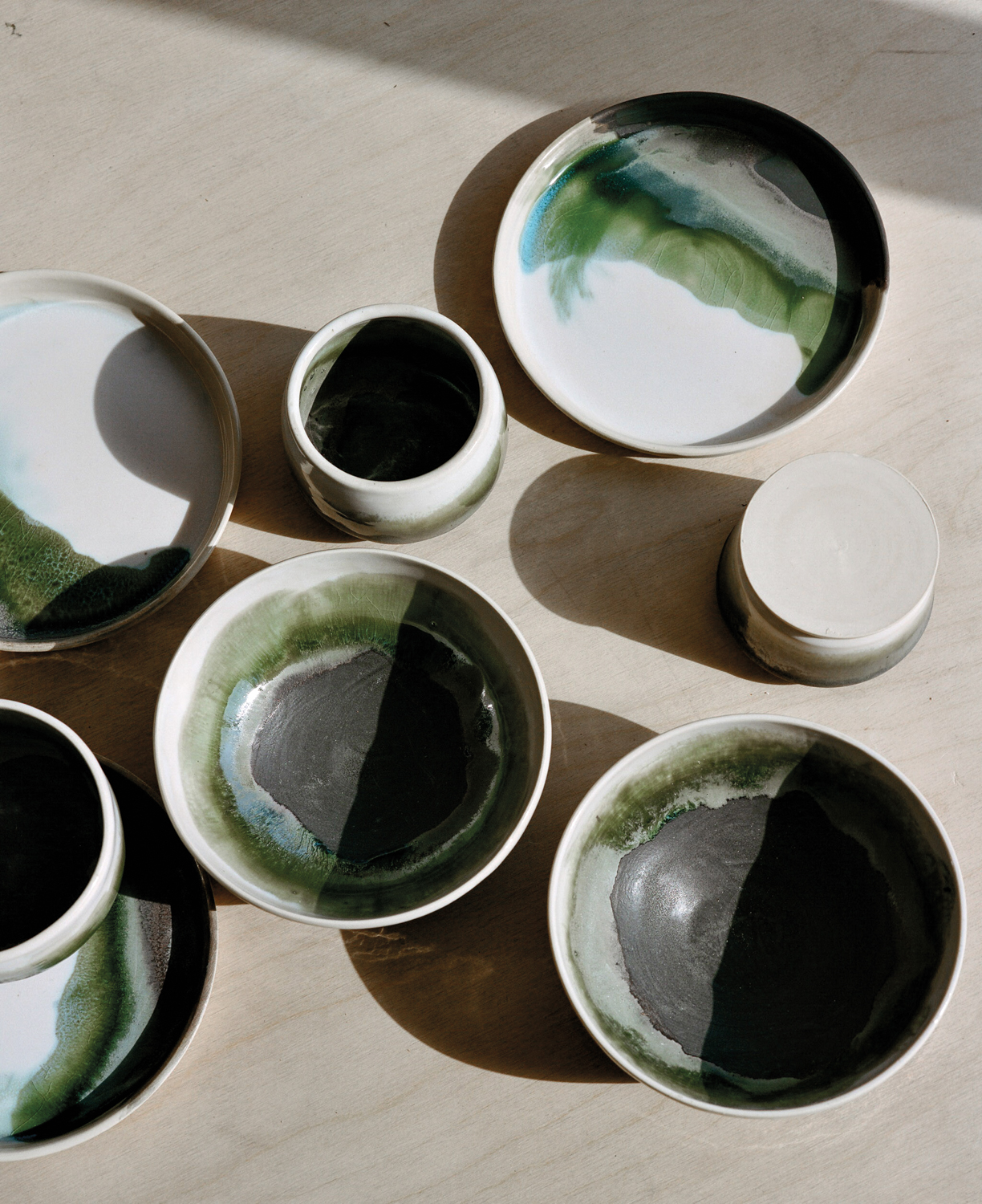 Ceramic bowls, plates and cups by OWIU goods on a table
