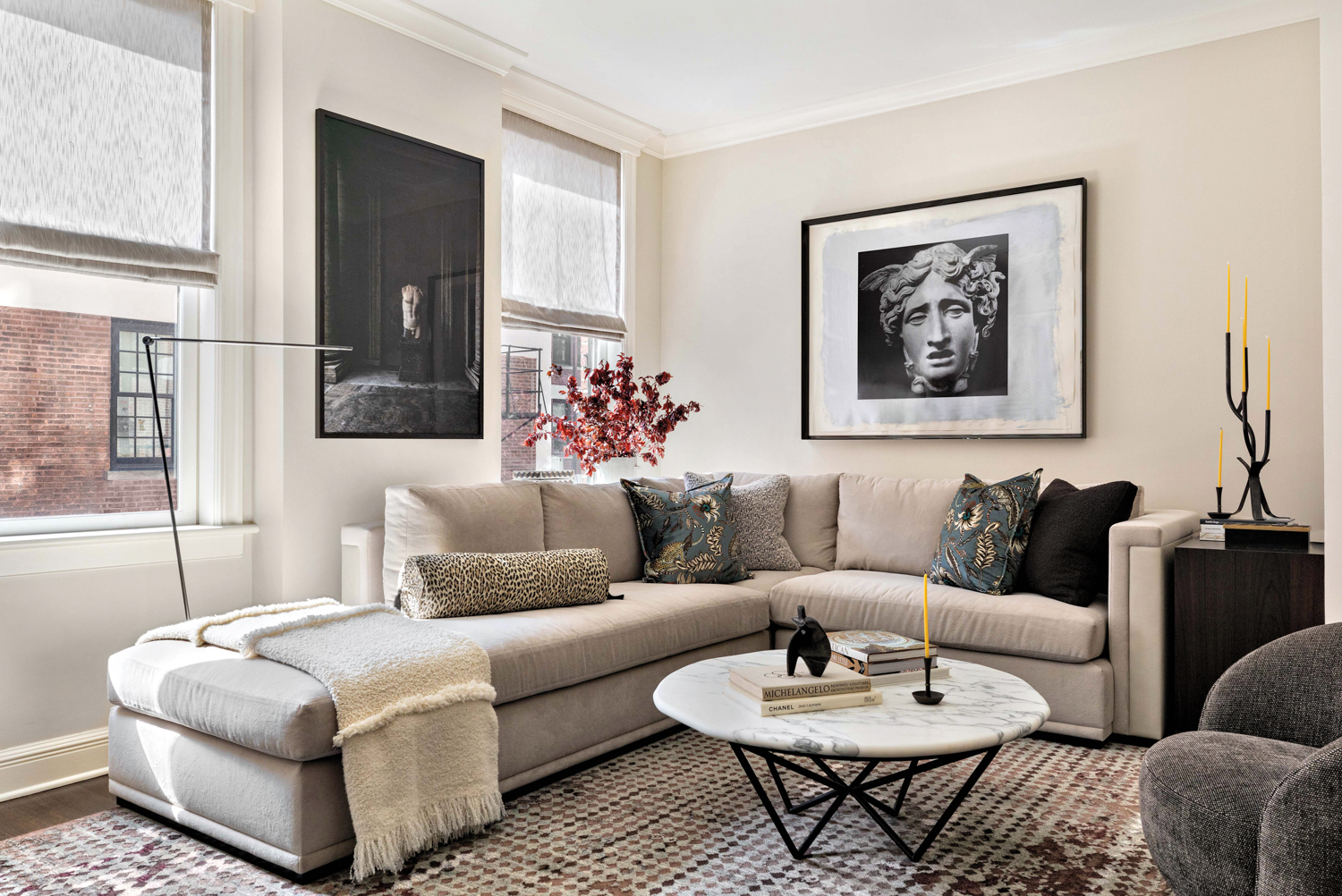 living room with gray sectional, black-and-white artworks and marble table in historic Chicago home