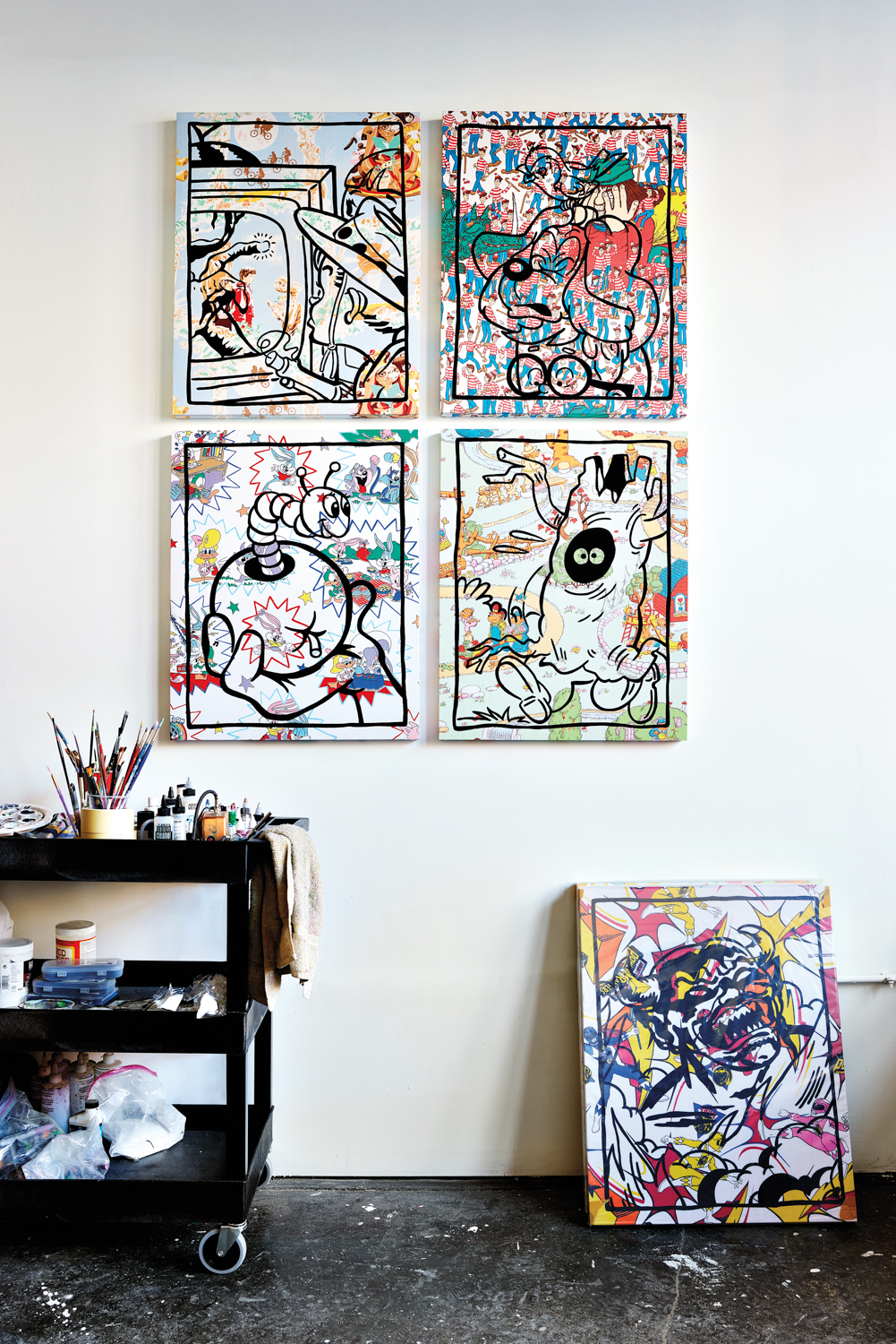 cartoon drawings and paintings hanging on the wall and one on the floor