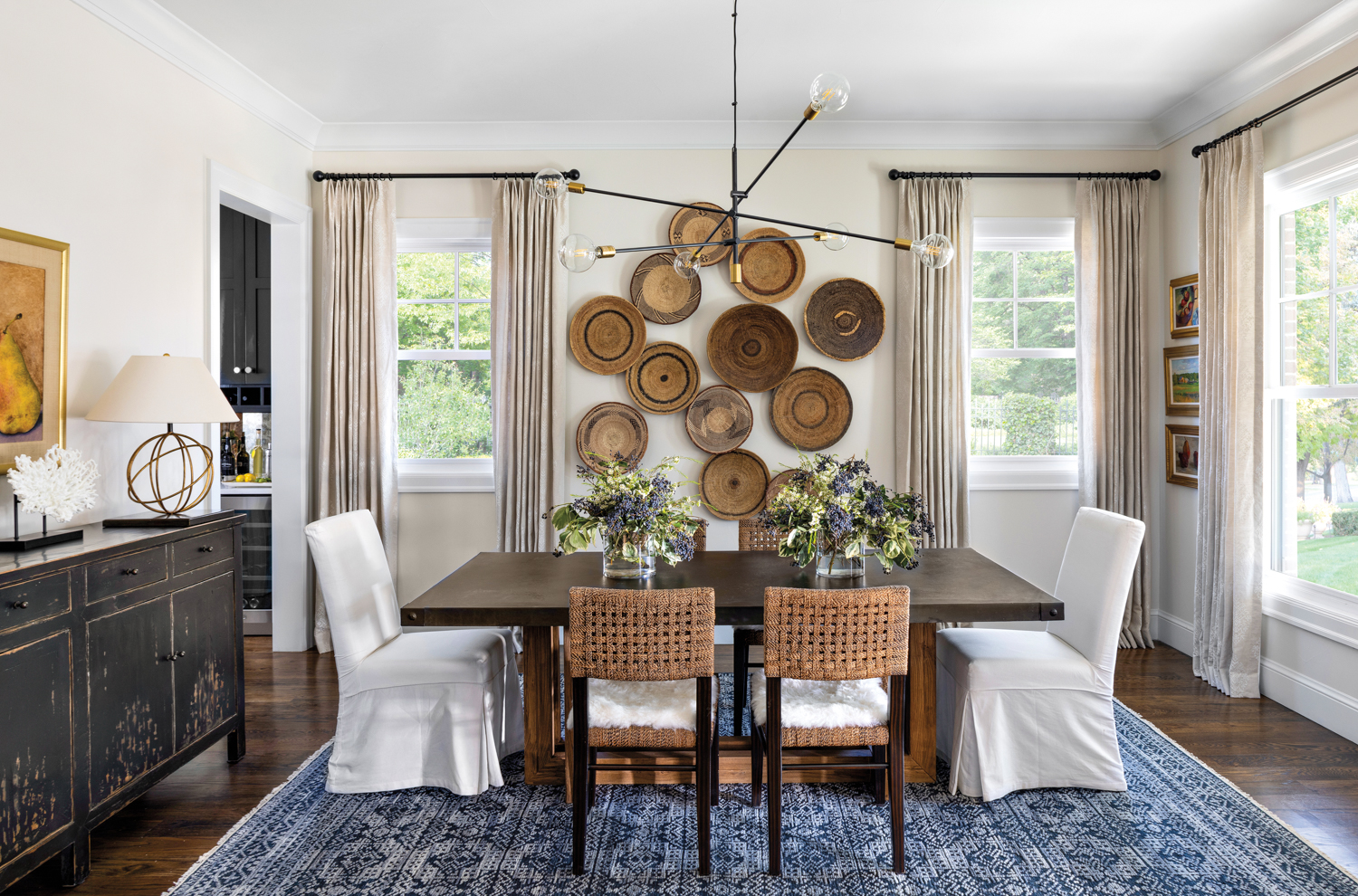 dining area with hanging basket collection, wood table, slipcovered chairs and dark blue rug
