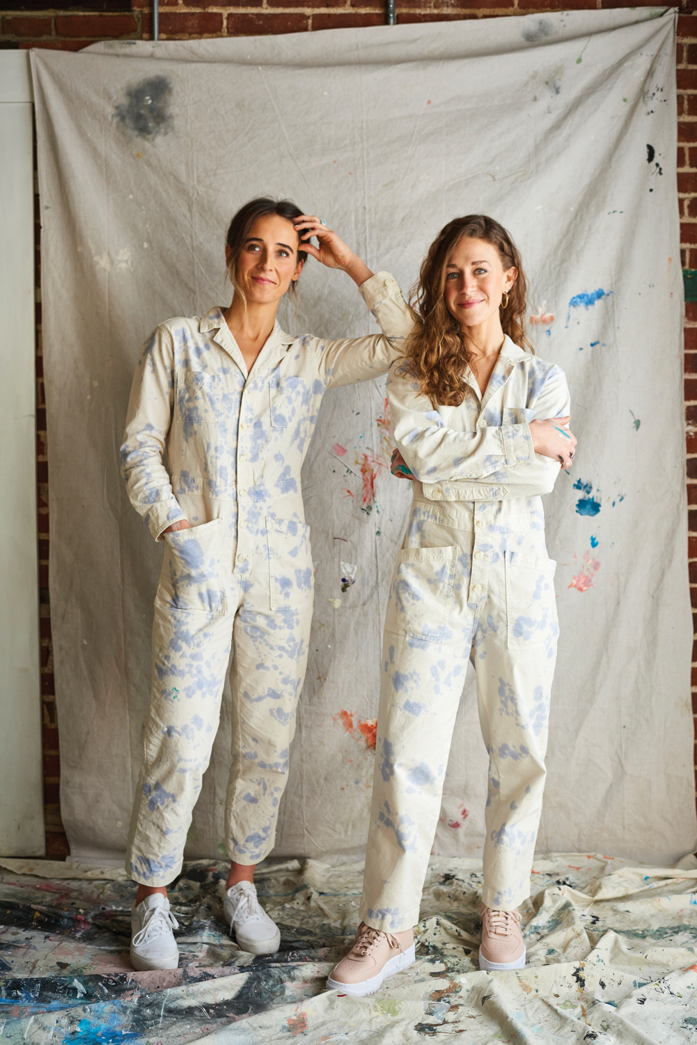 Portrait of Meredith Steele and Kristen Fogarty of Magik Studios wearing overalls in their studio