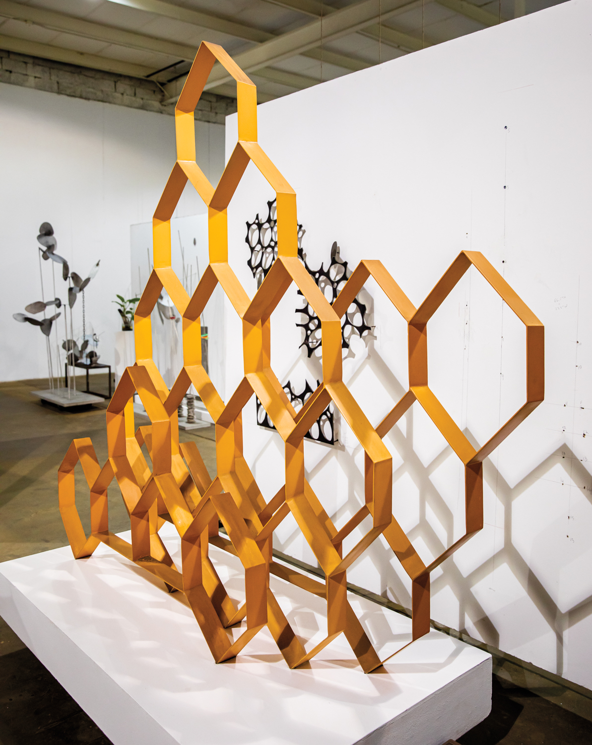 hexagonal orange metal sculptures in gallery