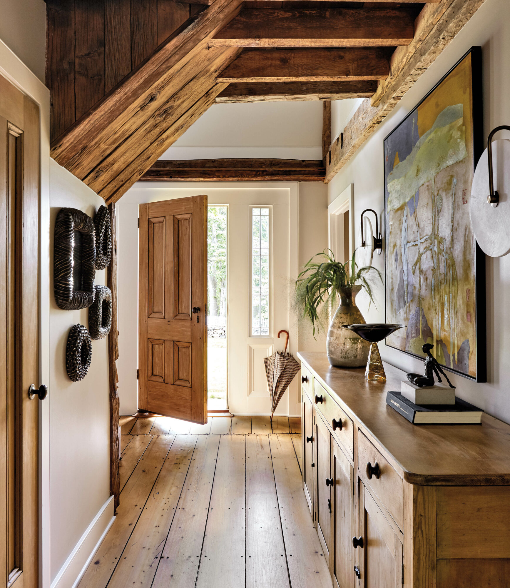 modern farmhouse entry way designed by Kathleen Walsh with wood floors and antique console