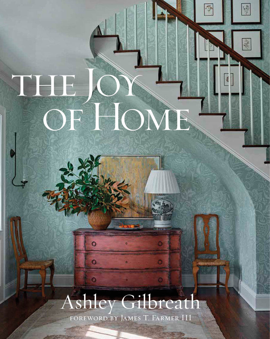 The Joy of Home design book featuring an entryway beneath a stairwell covered in floral-teal wallpaper
