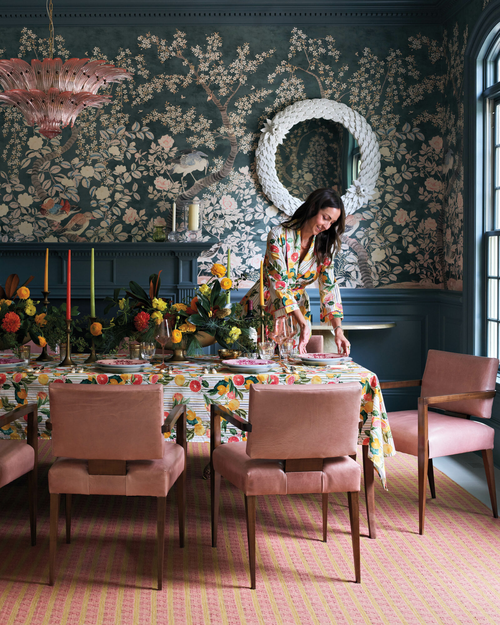 Charlotte Lucas, wearing a citrus-print dress, sets a table with a matching tablecloth and chairs
