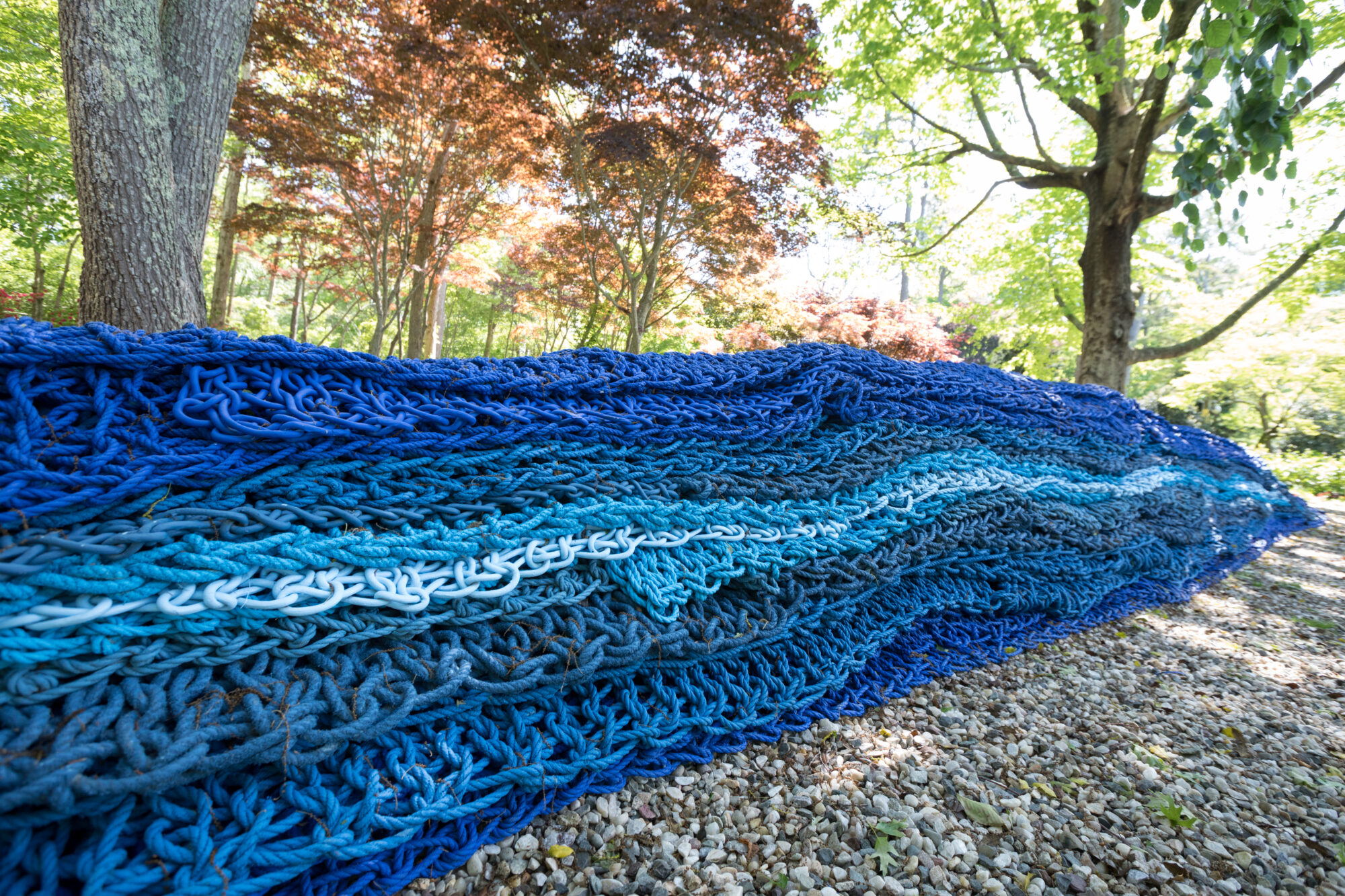 Large outdoor blue fiber art installation woven together at Narrative Threads: Fiber Art Today